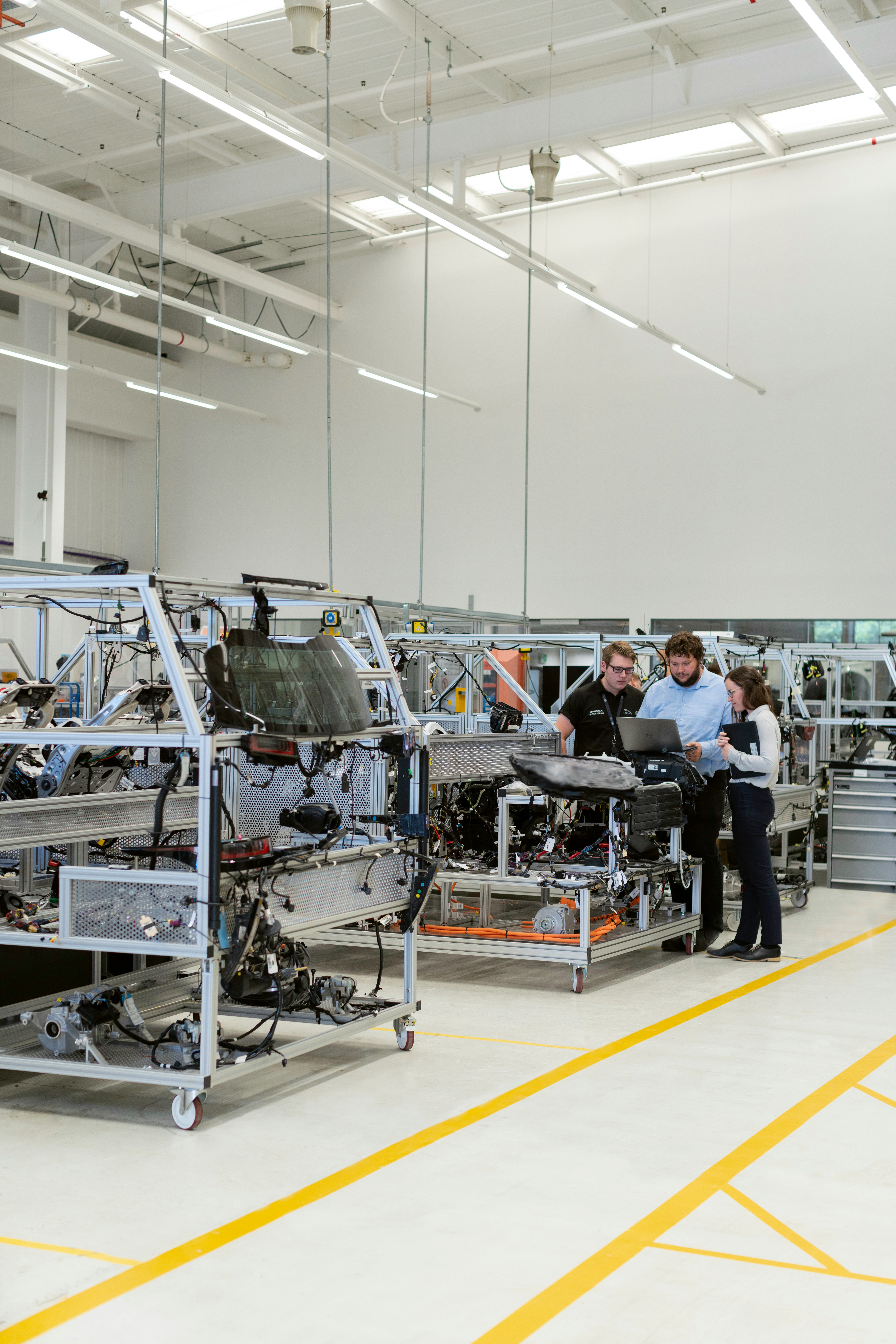 Manufacturing team reviewing product details beside production equipment